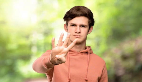 Adolescente Hombre Con Sudadera Feliz Contando Cuatro Con Los Dedos —  Fotos de Stock