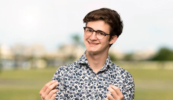 Teenager Man Flower Shirt Glasses Making Money Gesture Outdoors — Stock Photo, Image