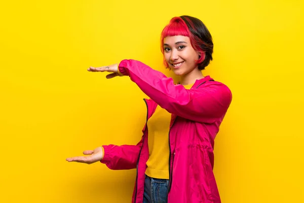 Mujer Joven Con Cabello Rosa Sobre Pared Amarilla Sosteniendo Espacio — Foto de Stock