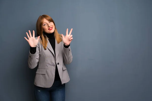 Redhead business woman counting eight with fingers