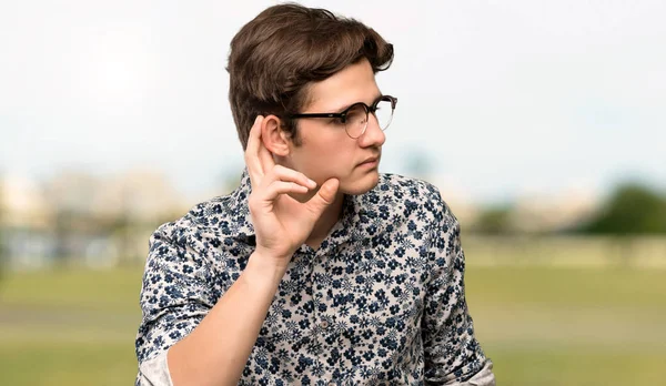 Adolescente Homem Com Camisa Flor Óculos Ouvindo Algo Colocando Mão — Fotografia de Stock