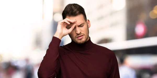 Man with turtleneck sweater with tired and sick expression in the city