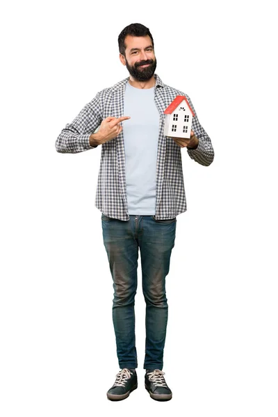 Un bel homme barbu tenant une petite maison — Photo