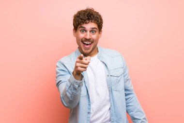 Sarışın adam pembe duvar mutlu ve ön işaretleme