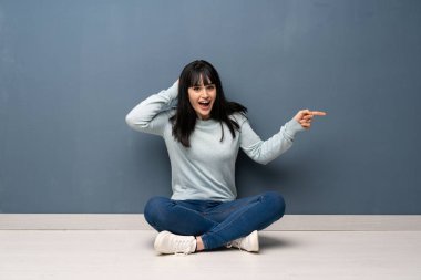 Yan kat şaşırmış ve işaret parmak üzerinde oturan kadın