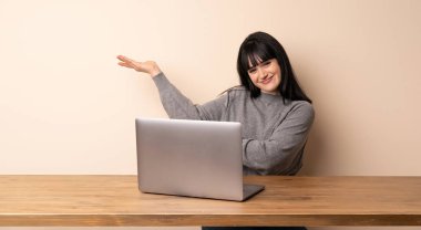 Eller yanına gelmek için davet için uzanan onu laptop ile çalışan genç kadın