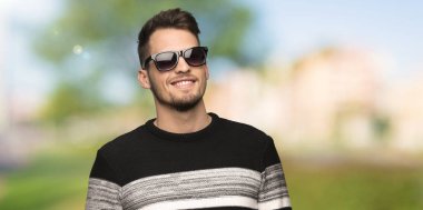Yakışıklı adam gözlüklü ve açık havada, mutlu