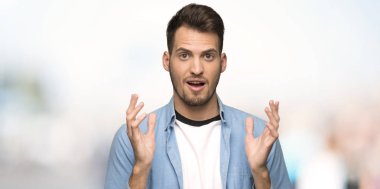 Yakışıklı adam açık havada, şok yüz ifadesi ile