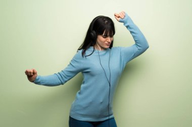 Kulaklık ile müzik ve dans yeşil duvar genç kadın