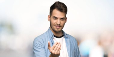 Yakışıklı adam el ile gelmek için davet. Mutlu açık havada geldi