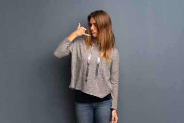 Gri arka plan üzerinde sarışın kadın telefon jest yapma ve şüphe