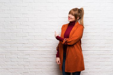 Kadın beyaz tuğla duvar geri işaret üzerinde kat ile