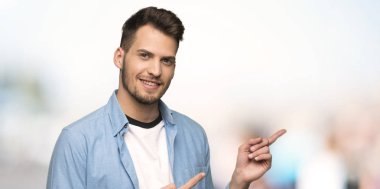 Yakışıklı adam açık havada tarafında işaret eden parmağa