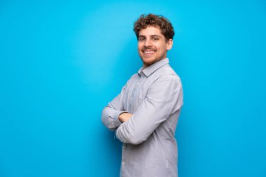 Sarışın adam geçti silah ile mavi duvar ve ileriye dönük