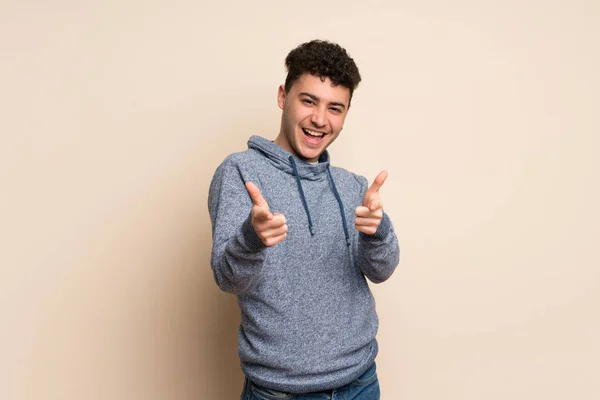 Joven Sobre Una Pared Aislada Apuntando Hacia Frente Sonriendo — Foto de Stock