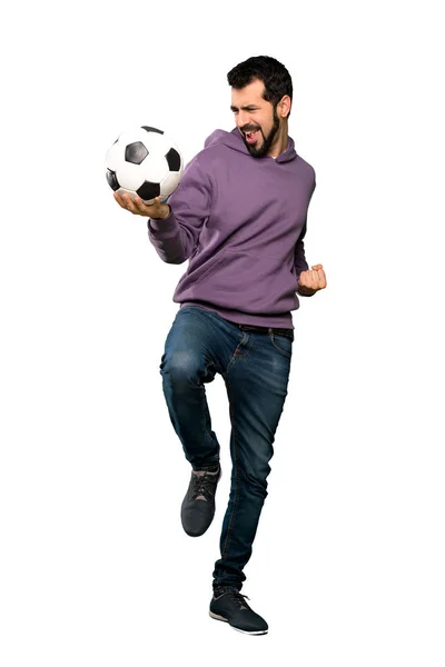 Красивый мужчина в толстовке держит футбольный мяч — стоковое фото