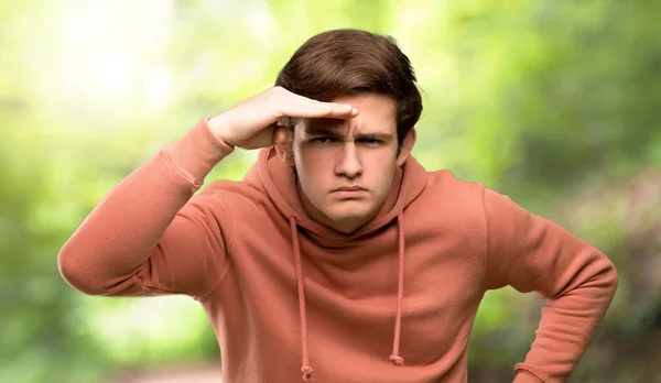 Jugendlicher Mann Mit Sweatshirt Schaut Mit Der Hand Weit Weg — Stockfoto