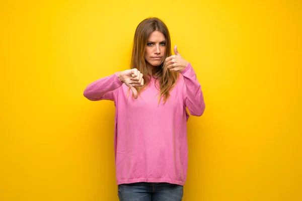 Vrouw Met Roze Trui Gele Muur Maken Van Goed Slecht — Stockfoto