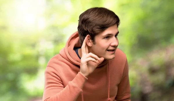Tonåringen Man Med Sweatshirt Lyssnar Något Genom Att Sätta Handen — Stockfoto
