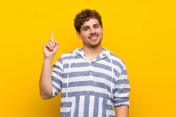 Hombre Rubio Sobre Pared Amarilla Mostrando Levantando Dedo Señal Mejor —  Fotos de Stock