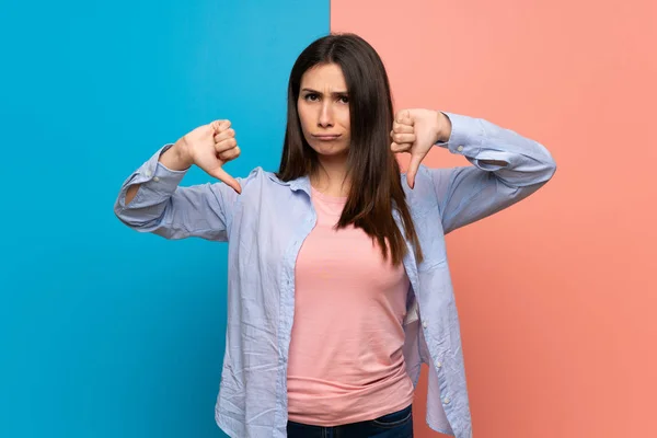 Young Woman Pink Blue Wall Showing Thumb Both Hands — Stock Photo, Image