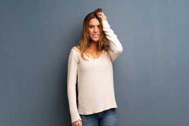 Hayal kırıklığı ve anlayış değil bir ifade ile gri arka plan üzerinde sarışın kadın