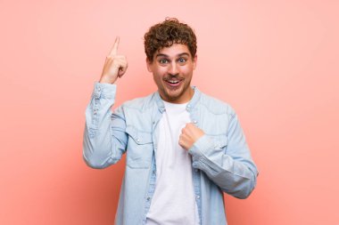 Sürpriz ve şok yüz ifadesi ile pembe duvar sarışın adam