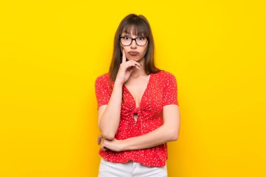 Sarı duvar Looking açık genç kadın