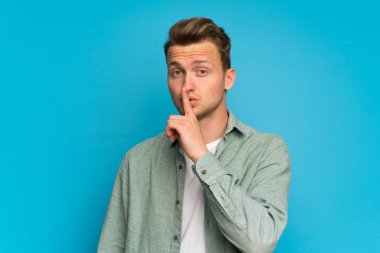 Yeşil tişörtlü sessizlik jest yapıyor sarışın yakışıklı adam