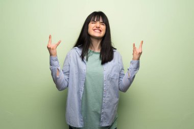 Yeşil duvar rock jest yapma genç kadın