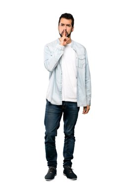 Bir işaret parmağını ağzına izole beyaz arka plan üzerinde koyarak sessizlik jest gösteren sakallı yakışıklı adam tam uzunlukta atış