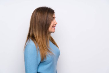 Ayakta ve tarafına bakarak mavi kazaklı genç kız