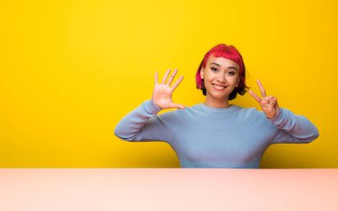 Yedi parmak ile sayma pembe saçlı genç kadın