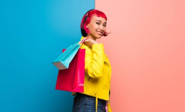 Sarı ceket bir sürü alışveriş torbaları tutan genç kadınla