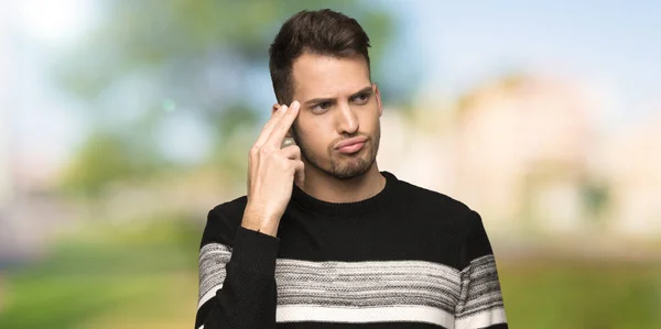 Handsome man with problems making suicide gesture at outdoors