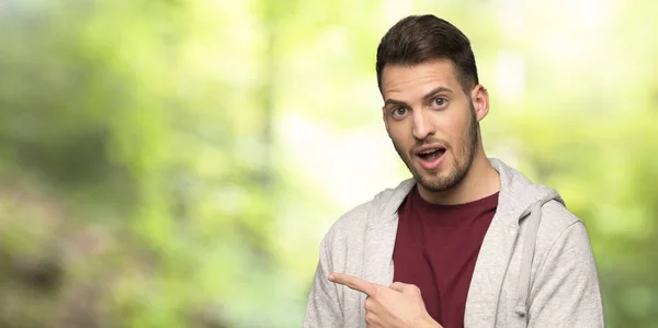 Hombre Con Sudadera Sorprendido Señalando Con Dedo Hacia Lado Parque —  Fotos de Stock