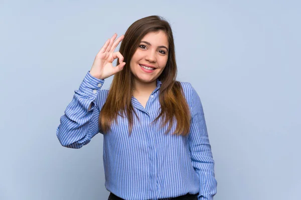 Молода Дівчина Над Ізольованою Синьою Стіною Показує Знак Пальцями — стокове фото