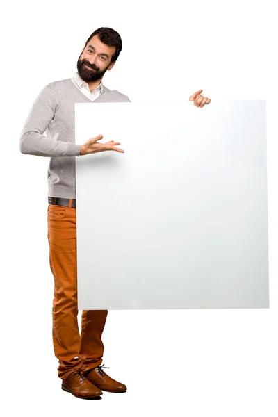 Homem bonito feliz com barba segurando um cartaz vazio — Fotografia de Stock