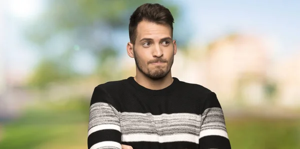 Handsome Man Making Doubts Gesture While Lifting Shoulders Outdoors — Stock Photo, Image