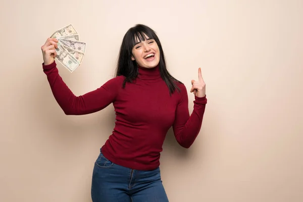 Young woman with red turtleneck taking a lot of money