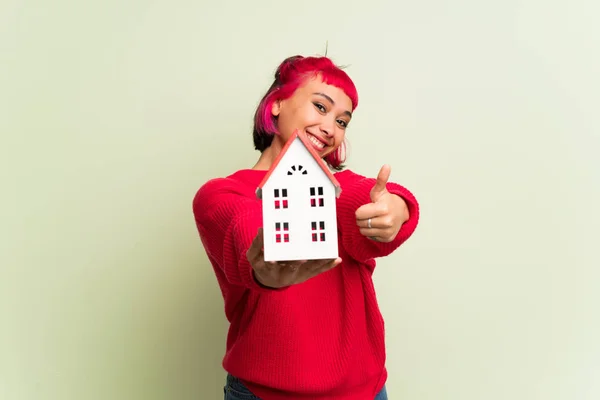 Νεαρή Γυναίκα Κόκκινο Πουλόβερ Κρατώντας Ένα Μικρό Σπίτι — Φωτογραφία Αρχείου