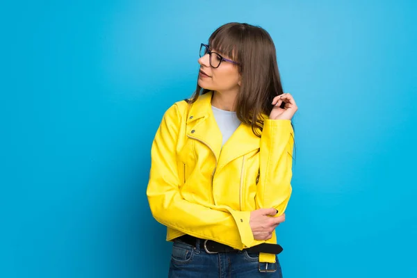 Genç Kadın Sarı Ceket Mavi Arka Tarafına Ile Çeneme Arıyorum — Stok fotoğraf