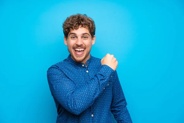 Homem Loiro Sobre Muro Azul Isolado Celebrando Uma Vitória — Fotografia de Stock