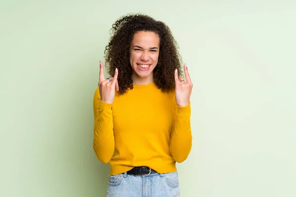 Mujer Dominicana Sobre Fondo Verde Aislado Haciendo Gesto Roca —  Fotos de Stock