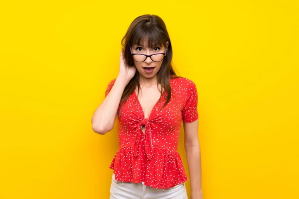 Młoda Kobieta Żółty Ścianę Okulary Zaskoczony — Zdjęcie stockowe