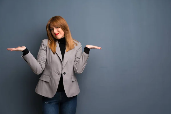 Redhead business woman making unimportant gesture while lifting the shoulders