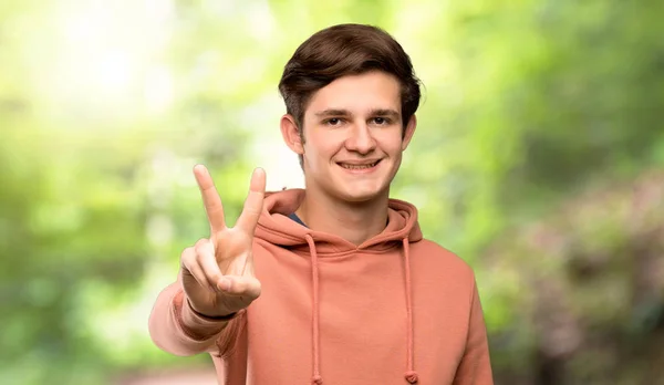 Чоловік Підліток Светром Посміхається Показує Знак Перемоги Відкритому Повітрі — стокове фото