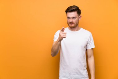 Kahverengi duvar üzerinde Redhead adam sinirli ve ön işaret