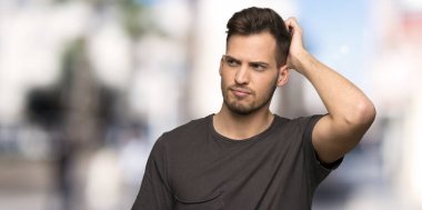 Açık havada çizmeye kafa iken şüphe sahip siyah gömlek ile adam