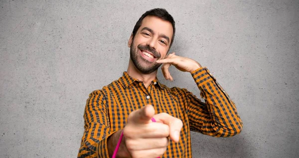 Man Shopping Bags Making Phone Gesture Pointing Front Textured Wall — Stock Photo, Image